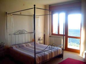 a bedroom with a canopy bed with a large window at Alla Torre Antica in Ruttàrs