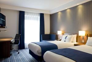 a hotel room with two beds and a desk at Holiday Inn Express Dunstable by IHG in Dunstable +40 photos