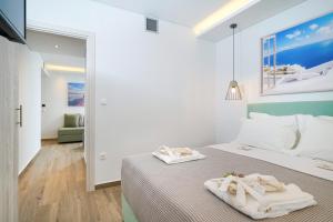 a bedroom with a bed with towels on it at Maria Elena Suites in Limenas +25 photos
