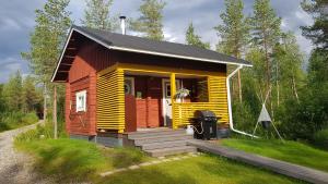a small red and yellow house with a porch at Salen Saunamökki in Ranua