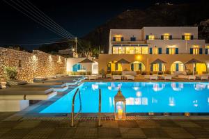 a hotel with a swimming pool at night at Marianna Hotel in Perissa