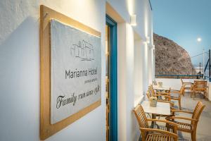 a sign on the wall of a restaurant with tables and chairs at Marianna Hotel in Perissa