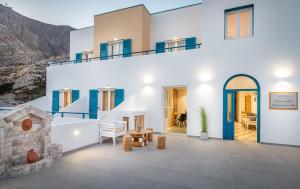 a house with white walls and blue accents at Marianna Hotel in Perissa