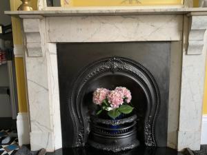 uma lareira preta com um vaso com flores em Chiltern Holiday apartments em Whitby