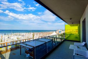 einen Balkon mit Blick auf einen Strand mit Sonnenschirmen in der Unterkunft Riva Mamaia Beach ApartHotel in Mamaia