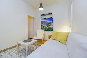 ein Wohnzimmer mit einem weißen Sofa und einem Tisch in der Unterkunft Apartman Veronika Zadar in Zadar