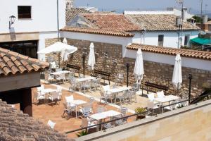 an outdoor patio with tables and white umbrellas at Hotel Rural Molino del Albaicín in Sabiote