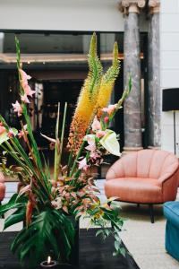 eine Vase mit Blumen auf einem Tisch im Wohnzimmer in der Unterkunft Hotel FRANQ in Antwerpen