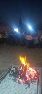 a fire pit in the sand at night at HOTEL BEACH CLUB LEGZIRA in Sidi Ifni