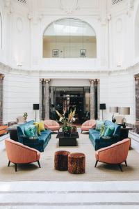un gran vestíbulo con sofás y mesas en un edificio en Hotel FRANQ, en Amberes