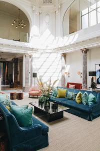 uma sala de estar com sofás azuis e uma mesa em Hotel FRANQ em Antuérpia
