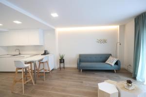 a living room with a blue couch and a kitchen at San Vicente Apartments in Avila