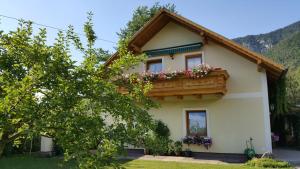 een huis met een balkon met bloemen erop bij Ferienhaus zur Maultrommel in Molln