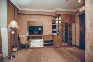 een kamer met een bureau, een televisie en een lamp bij Baku Hotel Ganja in Ganja