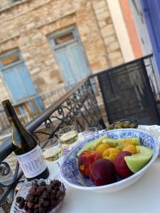 a table with a plate of fruit and a bottle of wine at the bougainvillea house in Symi +17 photos