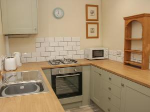 a kitchen with a sink and a microwave at Whitewater Cottage in Llangollen