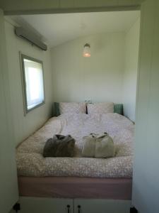 a bedroom with a bed with two bags on it at Roulotte Hartemeers in Tielt