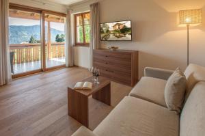 sala de estar con sofá y mesa en Hotel Girlanerhof en Appiano sulla Strada del Vino