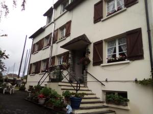 a white building with stairs and windows and potted plants at Lenard Charles Bed & Breakfast in Juvigny-sous-Andaine
