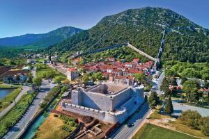 an aerial view of a town with a mountain at Apartments RGETO in Ston