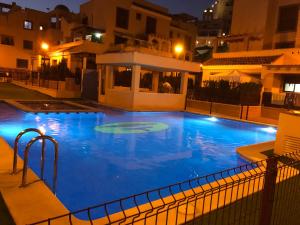 a large swimming pool with blue water at night at Apartamento María Isabel en Los Collados Golf - Aguilas in Águilas