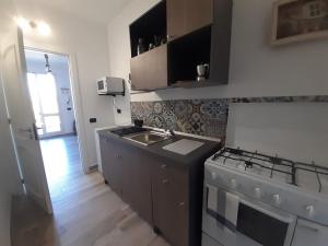 a small kitchen with a stove and a sink at La Casetta di Laura in Cefalù