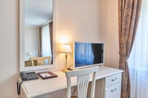 Zimmer mit einem Schreibtisch, einem Computer und einem Spiegel in der Unterkunft Spa Hotel Centrum in Franzensbad