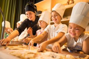 a group of children in chefs hats making pizza at Maistra Select Family Hotel Amarin in Rovinj