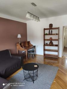 uma sala de estar com um sofá e uma mesa em ALEX Apartman em Sopron