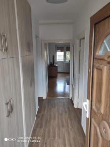 pasillo que conduce a una sala de estar con suelo de madera dura en ALEX Apartman, en Sopron