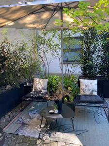 a patio with two couches and an umbrella at Luxury Omaruru-Design-Apartment Deluxe in Munich