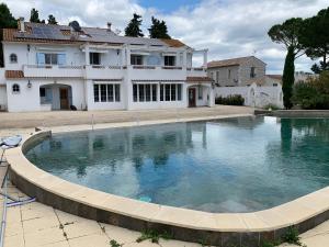 una grande piscina di fronte a una casa di Grand Tamaris Hosting a Arles