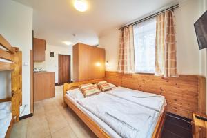 a bedroom with a bed and a large window at Pension Adrie in Janske Lazne