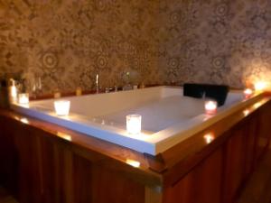 una bañera con velas y luces. en Hotel rural Finca Vivaldi Nature & Spa, en San Miguel de las Dueñas