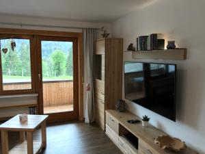ein Wohnzimmer mit einem Flachbild-TV an der Wand in der Unterkunft Almblick Ferienwohnung in Balderschwang