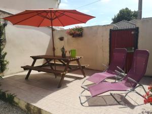 a table and two chairs with an umbrella on a patio at Maisonnette La Bienvenue in Trainel