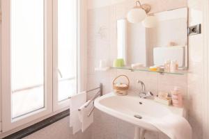 a white bathroom with a sink and a mirror at Hotel Mimosa in Alassio +106 photos