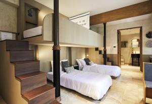 2 camas en una habitación con escalera en B House 49 Bangkok, en Bangkok