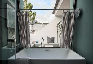 une baignoire dans une salle de bain avec une fenêtre dans l'établissement B House 49 Bangkok, à Bangkok
