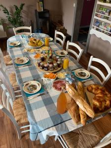 stół z jedzeniem, chlebem i sokiem pomarańczowym w obiekcie Chambres d'hôtes "La Bouill'hôte" w mieście Langensoultzbach