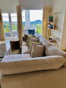 ein großes Sofa im Wohnzimmer mit großem Fenster in der Unterkunft LUXURY 3 BEDROOM HOUSE AT LA QUINTA GOLF COURSE OCEAN and MOUNTAIN VIEW in Benahavís