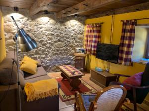 a living room with a couch and a tv at Casa Rural La Costurera in Los Espejos de la Reina