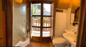 uma casa de banho com um WC, um lavatório e uma janela em Casa Rural La Costurera em Los Espejos de la Reina
