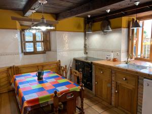 a kitchen with a table with a colorful table cloth at Casa Rural La Costurera in Los Espejos de la Reina