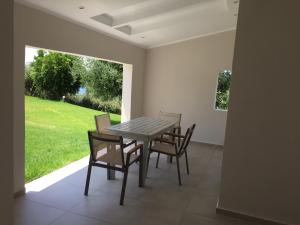 jadalnia ze stołem i 4 krzesłami w obiekcie Aliki Boutique Hotel w mieście Paralia Vrachou