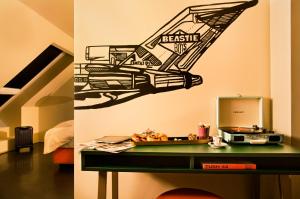 a bedroom with a desk with a stereo on the wall at JAMS Music Hotel Munich in Munich