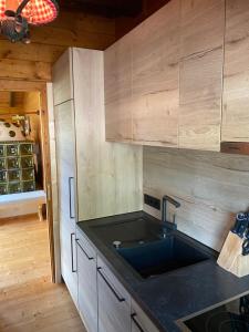 eine Küche mit einer Spüle und Holzschränken in der Unterkunft Ferienhaus Gasteg in Maria Alm am Steinernen Meer
