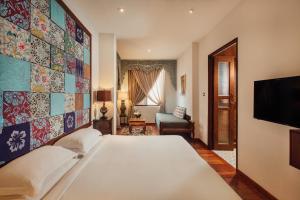 a bedroom with a large white bed and a tv at Campbell House in George Town