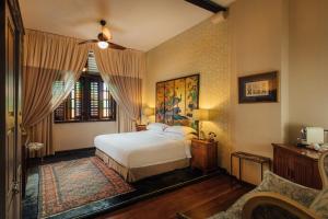 a bedroom with a white bed and a couch at Campbell House in George Town
