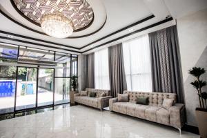 een woonkamer met 2 banken en een kroonluchter bij Gabrielle International Hotel in Tasjkent